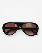 Reserve sunglasses by SWT, black aviator frame with burgundy gradient lenses, front view