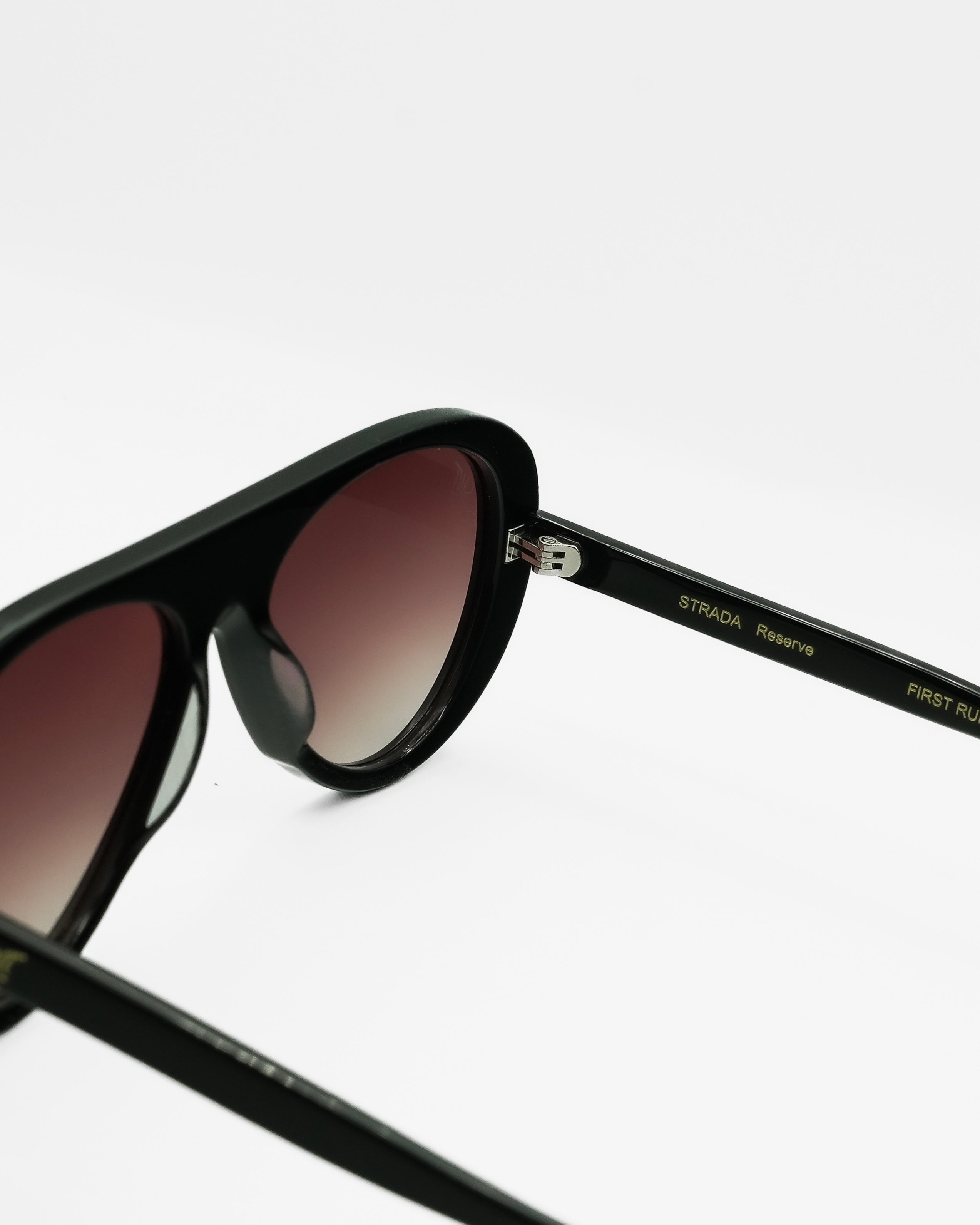 Reserve sunglasses by SWT, black aviator with burgundy gradient lenses, side view showing temple