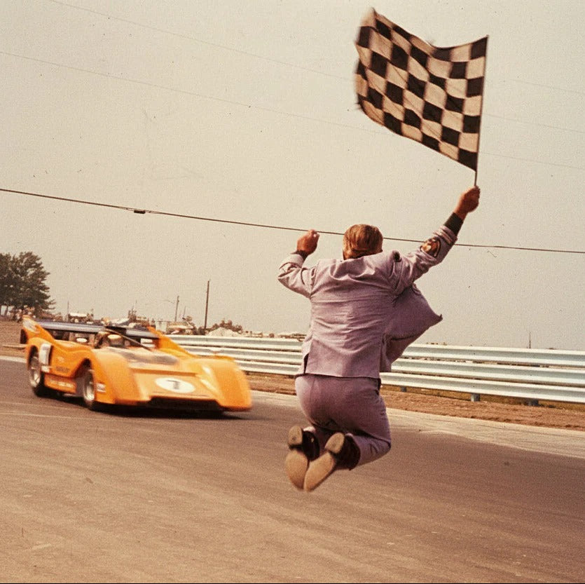 Vintage motorsport photo, chequered flag at the finish line
